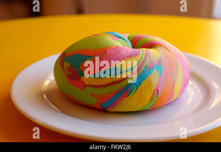 Brooklyn, New York, USA. 2. März 2016. Ein Regenbogen-Bagel, abgebildet auf einem Teller in Brooklyn, New York, USA, 2. März 2016. "Die Bagel Store" verkauft eine "Regenbogen-Bagel", ein buntes Gebäck, das durch seinen leicht süßlichen Geschmack auszeichnet. Foto: CHRISTINA HORSTEN/Dpa/Alamy Live News Stockfoto