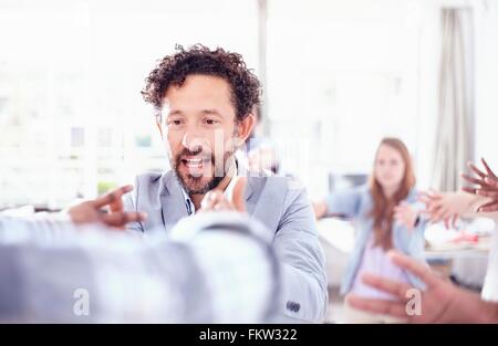 Bärtige reifer Mann im Team-building-Vortrag Hände angehoben lächelnd Stockfoto