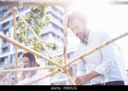 Niedrigen Winkel Ansicht reifer Mann im Team-building Aufgabe Gebäude Holzkonstruktion lächelnd Stockfoto