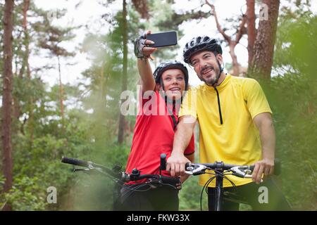 Happy Mountain Bike Paar posieren für Smartphone Selfie im Wald Stockfoto