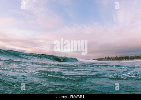 Fernsicht auf Surfer auf Ozeanwelle nahe Küste, Encinitas, Kalifornien, USA Stockfoto