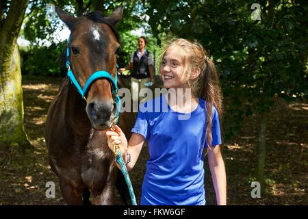 Mädchen halten Blei Seil Pferd lächelnd zu betrachten Stockfoto