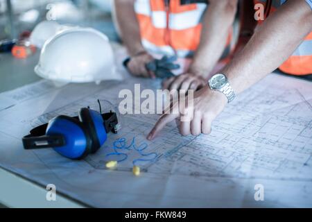 Nahaufnahme eines männlichen Hand auf Blaupause in Baustelle Stockfoto