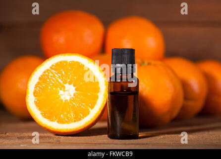 Flasche von ätherischen Ölen aus Orangen auf hölzernen Hintergrund - alternative Medizin Stockfoto