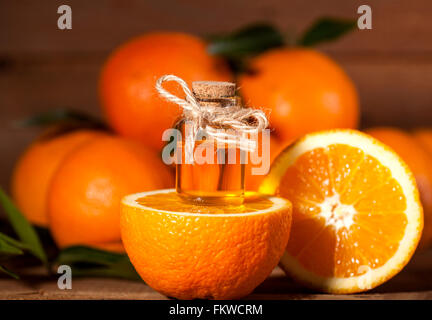 Flasche von ätherischen Ölen aus Orangen auf hölzernen Hintergrund - alternative Medizin Stockfoto