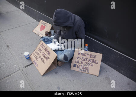 Mittelloser Mann bittet auf der 5th Avenue in New York mit Zeichen bitten um Hilfe, um seine kranke Mutter zu besuchen. Stockfoto