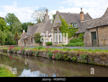 Englisch Stein Bungalows im traditionellen Stil der Cotswold Ufer des Flusses Auge mit wilden Blumen Stockfoto