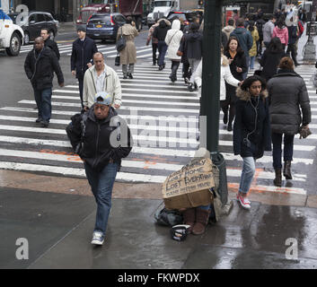 Person greift nach Hilfe mit einem Schild, wie der ständige Fluss von Fußgängern passieren auf 42nd St. & 5th Ave. In NYC Stockfoto