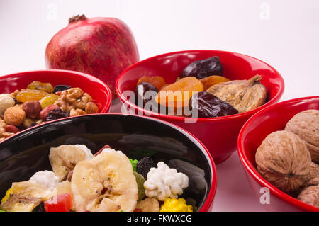 verschiedenen getrockneten Früchten, Nüssen und frischem Obst auf dem weißen Hintergrund gemischt Stockfoto