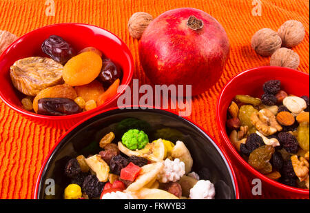 verschiedene getrocknete und frische Früchte auf dem Textil orange Hintergrund Stockfoto