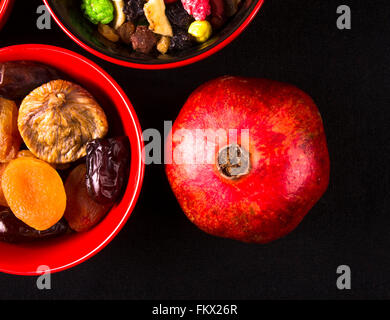 verschiedene getrocknete und frische Früchte auf dem schwarzen Hintergrund Stockfoto