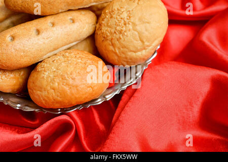 Brot in einen Metallkorb auf rotem Samt Untergrund platziert Stockfoto
