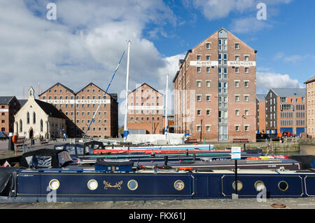 Schmale Boote vertäut vor umgebauten Lagerhäusern in Gloucester Docks Stockfoto