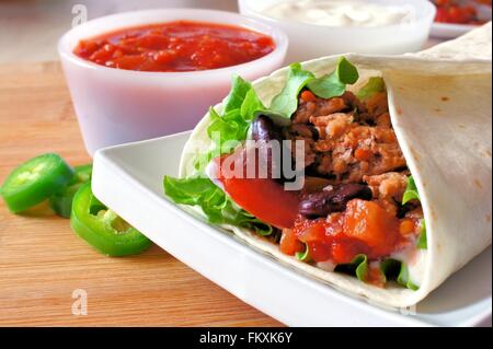 Nahaufnahme eines Burrito auf einer Platte mit Fleisch und Gemüse gefüllt Stockfoto