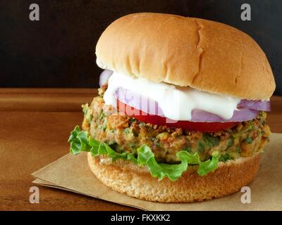 Warmen Falafel-Burger mit Salat, Tomaten und roten Zwiebeln mit Tzatziki sauce Stockfoto