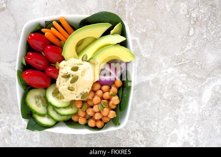 Gesundes Mittagessen Schüssel mit frischem Gemüse und Hummus, Draufsicht auf weißem Marmor Stockfoto