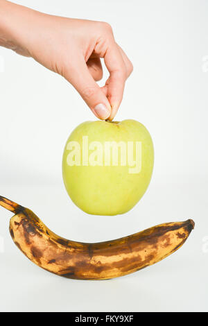 Faul und frisches Obst, Apfel und Banane, isoliert auf weiss Stockfoto