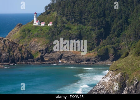 Malerischen Landzunge Felsen ragen im Vordergrund Heceta Head Lighthouse auf zentralen Küste Oregons. Ein beliebtes Wahrzeichen und Tourist Stockfoto