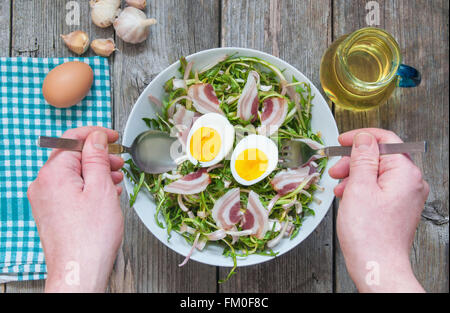 Frischer Löwenzahn Salat mit gekochten Eiern und Speck Stockfoto