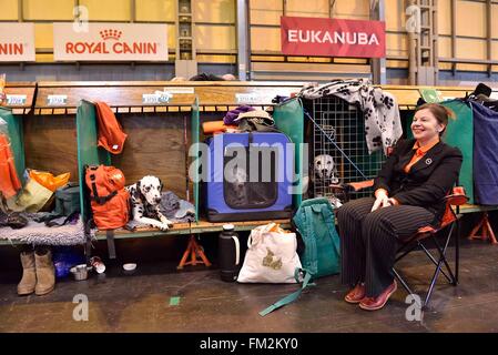 Birmingham, Großbritannien. 10. März 2016. Eine Frau sitzt mit ihren Hunden bei der Crufts Dog Show in Birmingham, Großbritannien, 10. März 2016. Die jährliche viertägige Veranstaltung, eröffnet am Donnerstag, ist eines der größten in der Welt. Bildnachweis: Ray Tang/Xinhua/Alamy Live-Nachrichten Stockfoto