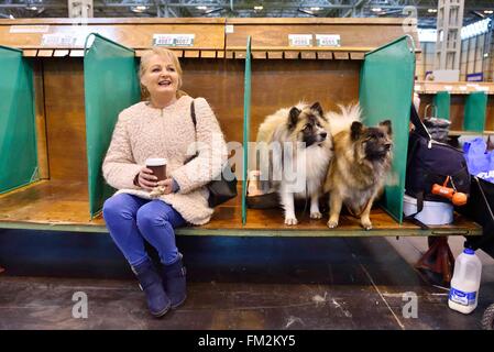 Birmingham, Großbritannien. 10. März 2016. Eine Frau sitzt mit ihren Hunden bei der Crufts Dog Show in Birmingham, Großbritannien, 10. März 2016. Die jährliche viertägige Veranstaltung, eröffnet am Donnerstag, ist eines der größten in der Welt. Bildnachweis: Ray Tang/Xinhua/Alamy Live-Nachrichten Stockfoto