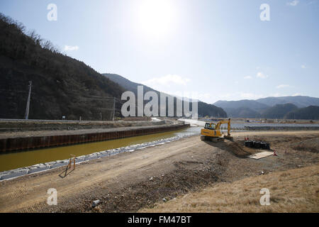 Deiche das Baugewerbe in der Nähe der Überreste der Okawa Elementary School am 11. März 2016 in Ishinomaki, Präfektur Miyagi, Japan. Genau 5 Jahre früheren 74 aus 108 Schüler verloren ihr Leben durch den Tsunami am 11. März 2011. Gibt es Pläne zum Wiederaufbau der Schulhaus, aber bisher hat dies nicht behoben. Das Schicksal der zerstörten Gebäude soll auch bald mit den Bewohnern der Stadt geteilt, ob sie als Mahnmal erhalten oder entfernt werden sollte entschieden werden. © Yusuke Nakanishi/AFLO/Alamy Live-Nachrichten Stockfoto