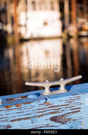 Liegeplatz Metallbügel auf Holz gemalt in blau Anlegeplatz für Boote, unscharf Yachten oder Marine auf dem Hintergrund Parkplatz Yachten. Stockfoto