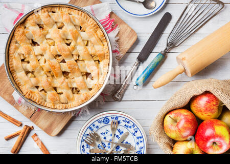 Hausgemachter Apfelkuchen und Zutaten auf einem rustikalen Tisch. Direkt von oben fotografiert. Stockfoto