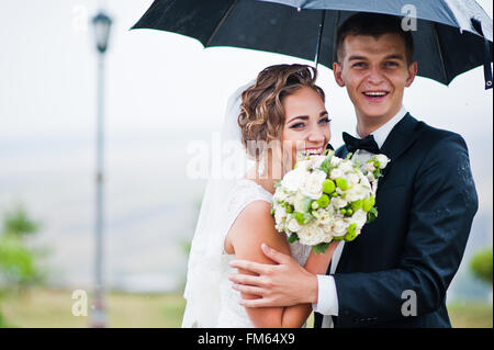 Glücklich lächelte Hochzeitspaar unter Dach Hintergrund Laterne Stockfoto