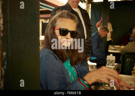 Alte Frau mit Sonnenbrille schaut in die Kamera, Miami, Florida Stockfoto