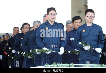 Tokio, Japan. 11. März 2016. Polizeibeamte bieten Chrysanthemen für den Tsunami und Erdbeben-Opfern, nachdem sie Überreste der vermissten Personen bei Namie in der Präfektur Fukushima in der Nähe der verkrüppelten TEPCO Kernkraftwerks auf Freitag, 11. März 2016 zum fünften Jahrestag der großen Erdbeben im Osten Japans gesucht. Kredite: Yoshio Tsunoda/AFLO/Alamy Live-Nachrichten Stockfoto