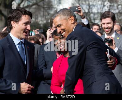 US-Präsident Barack Obama umarmt ein Mitglied der kanadischen Delegation, wie kanadische Premierminister Justin Trudeau, während der Staat Ankunft Zeremonie auf dem South Lawn des weißen Hauses 10. März 2016 in Washington, DC zusieht. Dies ist der erste Staatsbesuch eines kanadischen Premierministers in 20 Jahren. Stockfoto