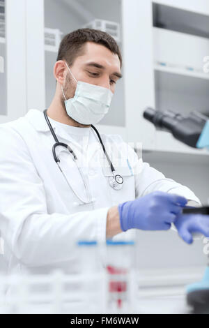 junge männliche Wissenschaftler mit Handschuhen im Labor Stockfoto