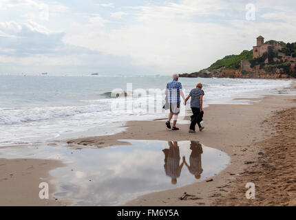 Älteres Paar zu Fuß in Strand Nähe Schloss von Tamarit in Tarragona, Katalonien, Spanien. Stockfoto