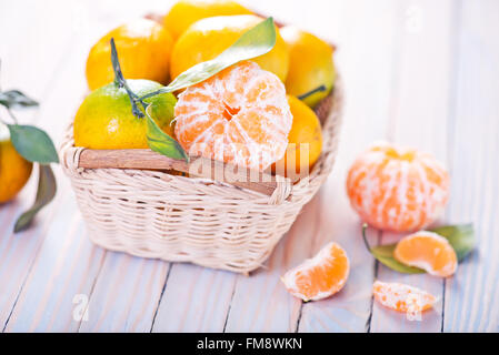 Mandarinen im Warenkorb und auf einem Tisch Stockfoto