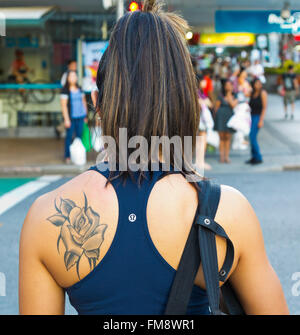 Schuss von Schulter Tattoo auf ein attraktives Mädchen Frau warten an der Ampel in Brisbane City Queensland Australien hautnah Stockfoto