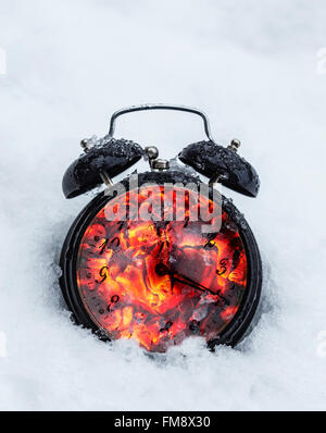 Gefrorene Uhr legen im Winterschnee, kombiniert mit heiße Kohle für Doppelbelichtung Konzept. Stockfoto