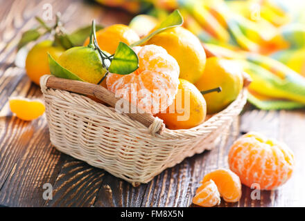 Mandarinen im Warenkorb und auf einem Tisch Stockfoto