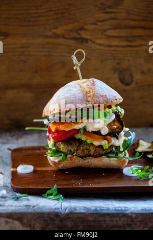 Vegetarische Burger gemacht aus Champignons, Kichererbsen und Brokkoli mit gebratenen Paprika, Auberginen, Rucola und Avocado pürieren Stockfoto