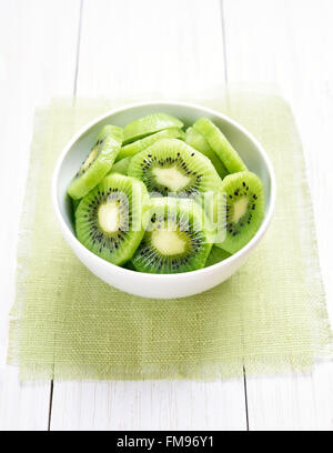 Kiwi-Scheiben in Schüssel weiß Stockfoto