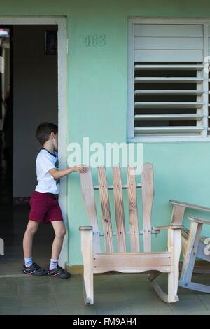 Kuba, Provinz Pinar del Rio, Vinales, Tal von Vinales als Weltkulturerbe von der UNESCO, junge Junge das Tragen einer schuluniform stehen auf der Terrasse eines bunten Haus Stockfoto