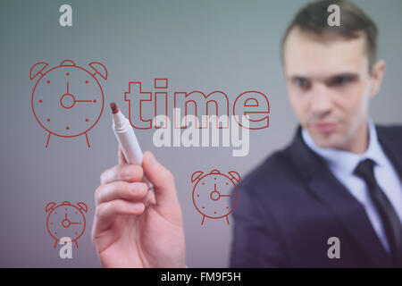 Geschäftsmann, schreiben auf einer transparenten Tafel - Zeit. gemalte Uhr Stockfoto