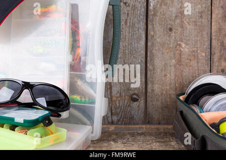 Angeln und Köder in Box mit Mütze Peak auf Holzbrettern Hintergrund für Outdoor-aktive Geschäftstätigkeit Stockfoto