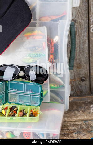 Angeln und Köder in Box mit Mütze Peak auf Holzbrettern Hintergrund für Outdoor-aktive Geschäftstätigkeit Stockfoto