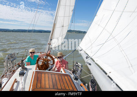 Ein glückliches senior Paar genießt Zeit zusammen Segeln auf einem See auf einem feinen Sommertag. Stockfoto