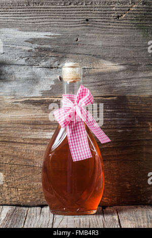 Glasflasche mit Korken am alten Holz Hintergrund Stockfoto