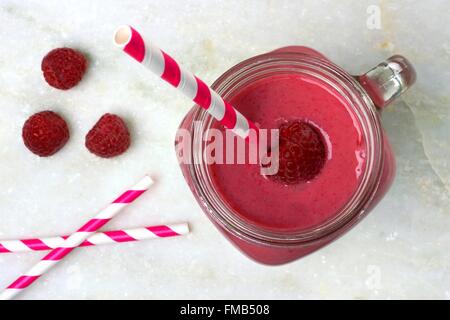 Rosa Himbeer Smoothie in ein Einmachglas, Draufsicht mit einem Strohhalm auf weißem Marmor Hintergrund Stockfoto