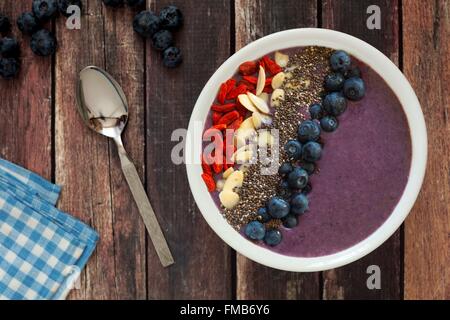 Smoothie Heidelbeere Schüssel mit Mandeln, Goji Beeren und Chia Samen auf einem urigen alten Holztisch Stockfoto