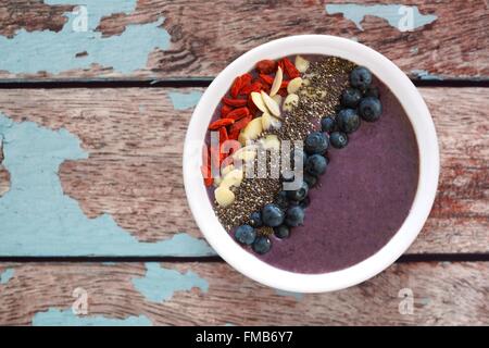 Gesunde smoothie Heidelbeere Schüssel mit Mandeln, Goji Beeren und Chia Samen auf einem urigen alten Holz Hintergrund Stockfoto