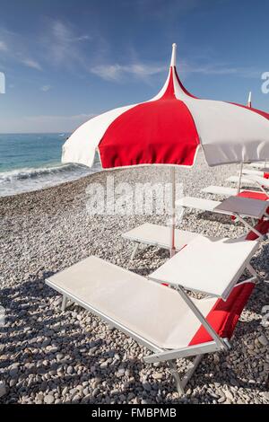 Frankreich, Alpes Maritimes, Cagnes Sur Mer, Sonnenliegen und Sonnenschirmen auf den Stein Strand Stockfoto